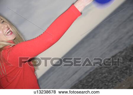 Woman playing with a frisbee, throwing and catching, in front of dark clouds View Large Photo Image Stock Photo - Woman playing with a frisbee, throwing and catching, in front of dark clouds. Fotosearch