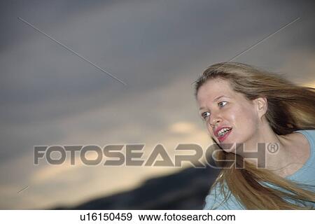 Stock Photo - Young blond woman jogging at the beach, portrait. Fotosearch