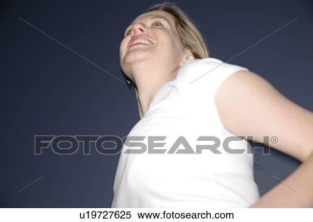 Stock Photography - Young blond woman standing, at night. Fotosearch