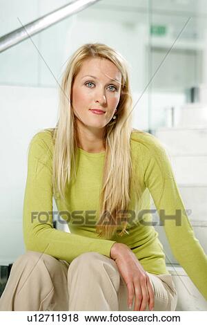 Young business woman with long blond hair sitting on stairs in office building View Large Photo Image Stock Photo - Young business woman with long blond hair sitting on stairs in office building. Fotosearch