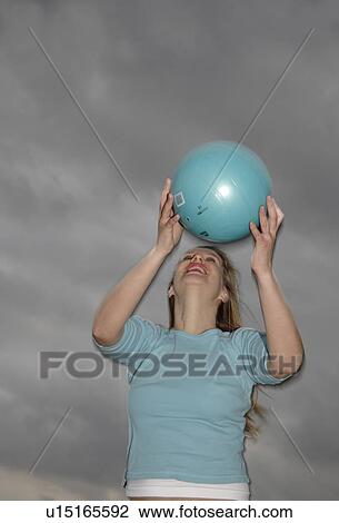Young woman playing with a ball at the beach View Large Photo Image Stock Image - Young woman playing with a ball at the beach. Fotosearch