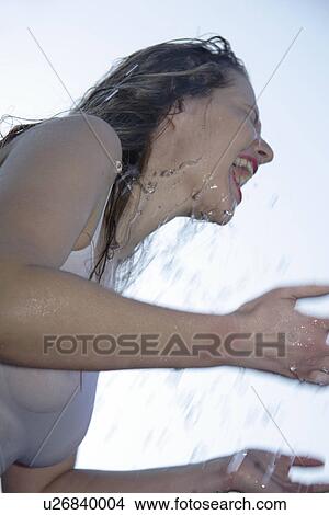 Young woman refreshing herself by splashing water all over her body, low angle view, close up View Large Photo Image Picture - Young woman refreshing herself by splashing water all over her body, low angle view, close up. Fotosearch
