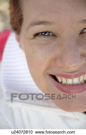 Stock Image - Young woman smiling, portrait, close up. Fotosearch
