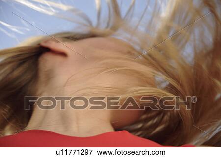 Young woman throwing her long blond hair in front of blue sky, low angle view View Large Photo Image Stock Photo - Young woman throwing her long blond hair in front of blue sky, low angle view. Fotosearch