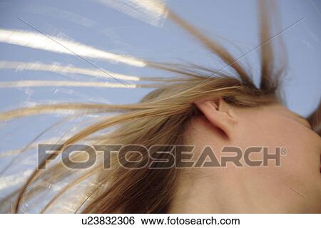 Young woman throwing her long blond hair in front of blue sky, low angle view View Large Photo Image Stock Photograph - Young woman throwing her long blond hair in front of blue sky, low angle view. Fotosearch