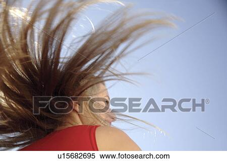 Young woman throwing her long blond hair in front of blue sky, low angle view View Large Photo Image Stock Photography - Young woman throwing her long blond hair in front of blue sky, low angle view. Fotosearch