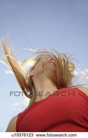 Young woman tossing her long blond hair in front of blue sky, view from below View Large Photo Image Stock Image - Young woman tossing her long blond hair in front of blue sky, view from below. Fotosearch