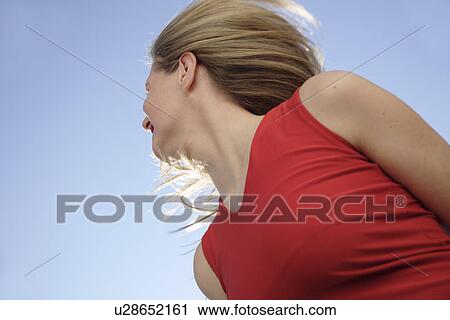 Young woman tossing her long blond hair in front of blue sky, view from below View Large Photo Image Stock Image - Young woman tossing her long blond hair in front of blue sky, view from below. Fotosearch