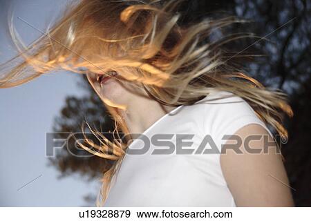 Young woman tossing her long blond hair outdoors, view from below View Large Photo Image Stock Photo - Young woman tossing her long blond hair outdoors, view from below. Fotosearch