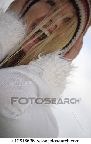 Young woman wearing knitted cap, running and laughing at the beach, close up View Large Photo Image Stock Photograph - Young woman wearing knitted cap, running and laughing at the beach, close up. Fotosearch
