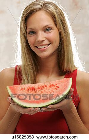 Young woman with long blond hair eating a slice of watermelon, portrait View Large Photo Image Stock Photo - Young woman with long blond hair eating a slice of watermelon, portrait. Fotosearch