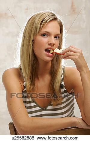 Young woman with long blond hair eating an apple, portrait View Large Photo Image Stock Photo - Young woman with long blond hair eating an apple, portrait. Fotosearch