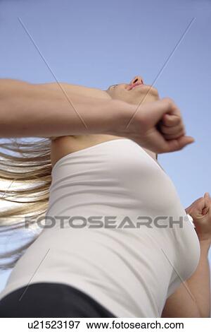 Young woman with long blond hair running at the beach, worm's eye view View Large Photo Image Stock Photo - Young woman with long blond hair running at the beach, worm's eye view. Fotosearch