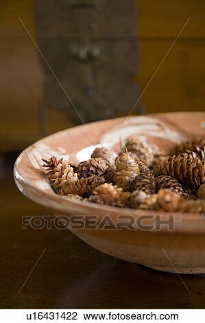 Stock Image - Detail of bowl filled with miniature pinecones.. Fotosearch