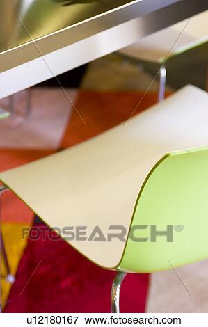 Stock Photo - Modern Green Plastic Chair on Bright Rug. Fotosearch