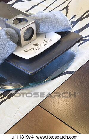 Picture - Place setting with plates and napkin with napkin ring (close up). Fotosearch