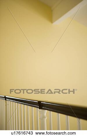 Stock Image - Wooden Bannister Railing and Yellow Walls. Fotosearch