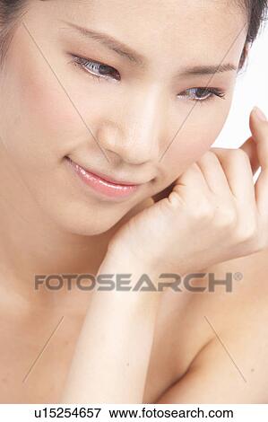 Stock Photo - Portrait of Natural Young girl with hands next to face. Fotosearch
