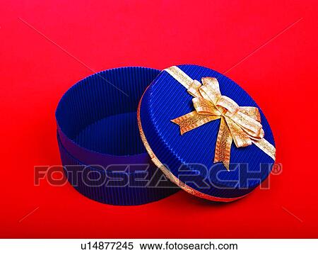Stock Photography - Round shaped box with golden bow, elevated view. Fotosearch