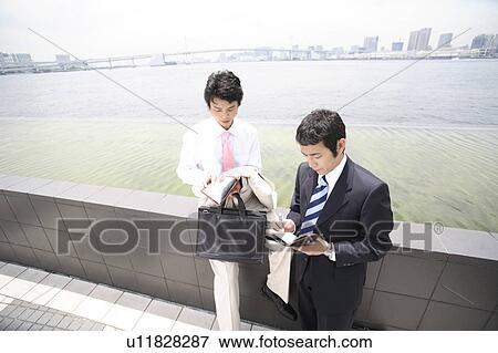 Stock Photo - Businessmen having a short meeting. Fotosearch