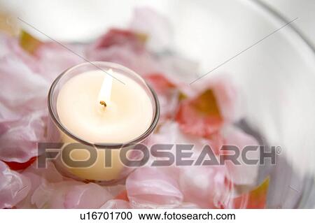 Stock Image - Candle floating in the water of a bowl. Fotosearch