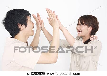 Stock Image - Couple doing high-fives. Fotosearch