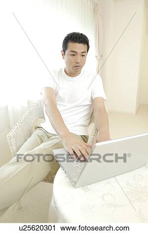 Man operating a laptop computer View Large Photo Image Stock Image - Man operating a laptop computer. Fotosearch