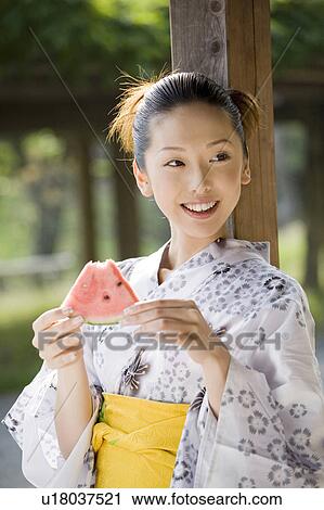 Stock Image - Woman who eats a watermelon. Fotosearch