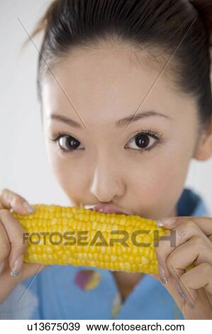 Woman who nibbles a cob of corn View Large Photo Image Stock Photo - Woman who nibbles a cob of corn. Fotosearch