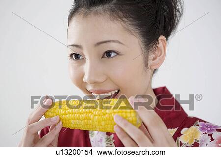 Woman who nibbles a corn View Large Photo Image Picture - Woman who nibbles a corn. Fotosearch