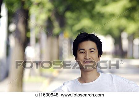 Young man standing in the street View Large Photo Image Stock Photo - Young man standing in the street. Fotosearch