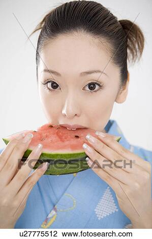 Stock Image - Yukata woman eating watermelon. Fotosearch