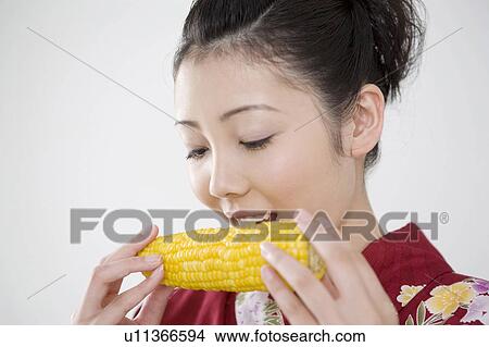 Picture - Yukata woman who nibbles a corn. Fotosearch