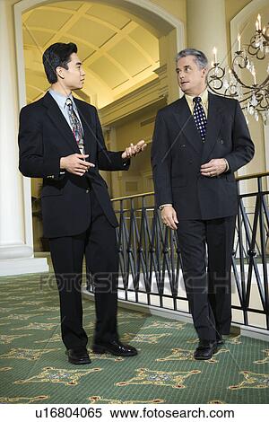 Stock Photography - Adult businessmen in hotel.. Fotosearch