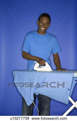 Boy smiling and ironing shirt View Large Photo Image Stock Photo - Boy smiling and ironing shirt . Fotosearch