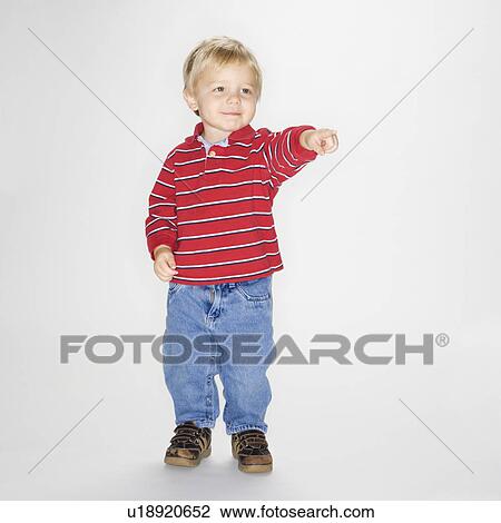 Boy standing and pointing against white background View Large Photo Image Stock Image - Boy standing and pointing against white background. Fotosearch