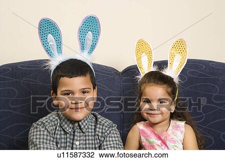 Brother and sister wearing bunny ears smiling and looking at viewer View Large Photo Image Stock Image - Brother and sister wearing bunny ears smiling and looking at viewer. Fotosearch