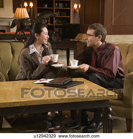 Stock Photo - business people drinking coffee and conversing.. Fotosearch