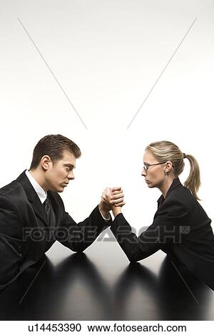 Businessman and businesswoman arm wrestling on table View Large Photo Image Stock Image - Businessman and businesswoman arm wrestling on table. Fotosearch