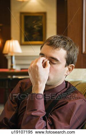 Businessman holding forehead with eyes closed View Large Photo Image Stock Photography - Businessman holding forehead with eyes closed. Fotosearch