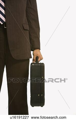 Businessman in suit holding briefcase View Large Photo Image Stock Photo - Businessman in suit holding briefcase. Fotosearch