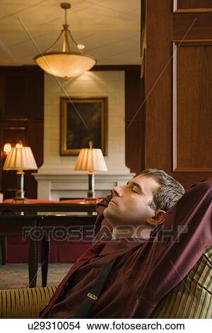 Picture - Businessman reclining with arms behind head and eyes closed. Fotosearch