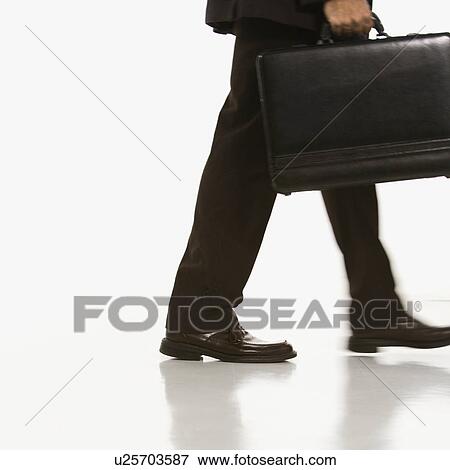 Businessman walking carrying briefcase View Large Photo Image Stock Photo - Businessman walking carrying briefcase. Fotosearch