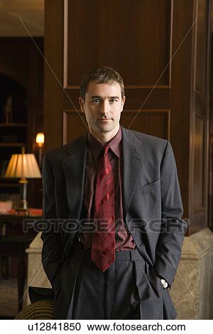 Stock Image - Businessman with hands in pockets. Fotosearch