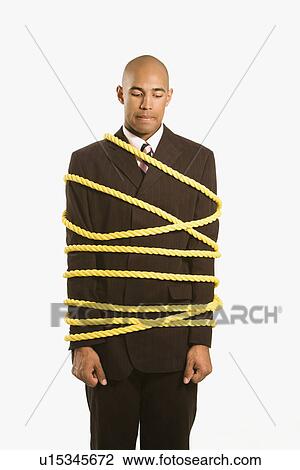 Stock Image - businessman wrapped in yellow rope. Fotosearch