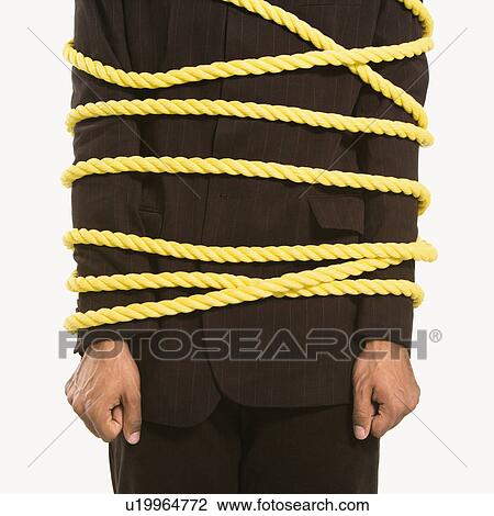 Businessman wrapped in yellow rope View Large Photo Image Stock Image - Businessman wrapped in yellow rope. Fotosearch