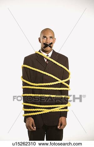 Businessman wrapped in yellow rope with tape over his mouth View Large Photo Image Stock Image - Businessman wrapped in yellow rope with tape over his mouth. Fotosearch