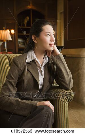 Stock Image - Businesswoman looking to side with head resting on hand. Fotosearch