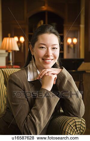 Stock Photo - Businesswoman smiling with chin resting on hands. Fotosearch