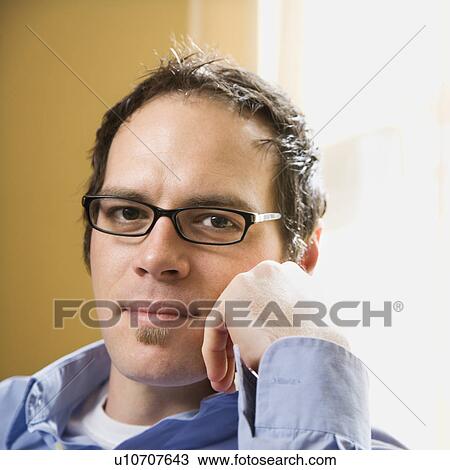Caucasian mid adult man wearing glasses and looking at viewer with hand to face. View Large Photo Image Stock Image - Caucasian mid adult man wearing glasses and looking at viewer with hand to face.. Fotosearch